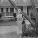 Marylin standing outside her home.